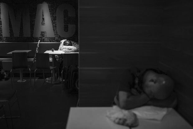 Men sleep at a 24-hour McDonald's restaurant in Hong Kong, China November 11, 2015. A large number of homeless people sleeping on the street has long been been a problem in Hong Kong mainly due to its high rents and soaring property prices. In recent years, the opening of McDonald's 24-hour fast food restaurants all over the city have become popular alternatives for homeless people known as McRefugees or McSleepers to spend the night in a safer and more comfortable way than on the street. REUTERS/Tyrone Siu - RTS6EZX