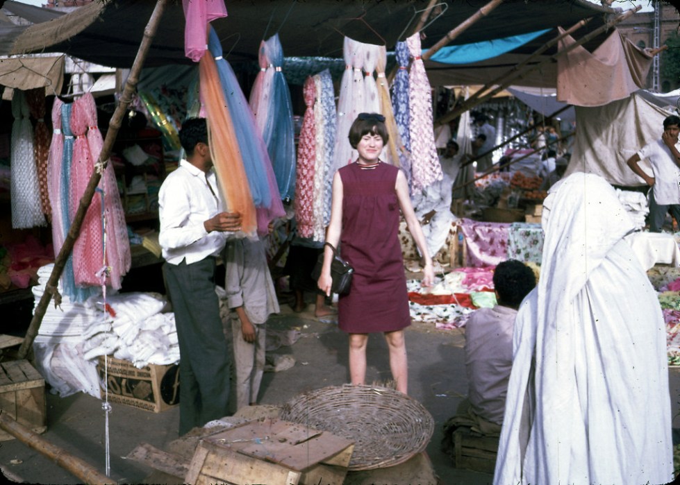 "Jan Podlich on a shopping trip in Istalif. Jan in a short, sleeveless dress and the woman to the right in a chadri (burka). We arrived in Kabul one sunshiny morning in June... My dad met us and was able to whisk us through the customs. We proceeded into Kabul in a UN ÒkombiÓ (kind of an old school SUV). I was tired, but I can remember being amazed at the sight of colorful (dark blue, green and maroon) ÒghostsÓ that were wafting along the side of the road. My dad explained there were women underneath those chadris, and that some women had to wear them out in public. We never called the garments Òburkas.Ó Depending on the country, women practicing purdah (Islamic custom requiring women to cover up) wear different styles of coverings, which have different names." - Peg Podlich. "
